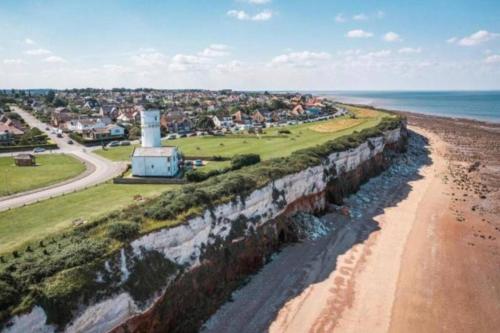 an aerial view of a beach with a lighthouse at Close to beach. Two bed compact flat. in Hunstanton