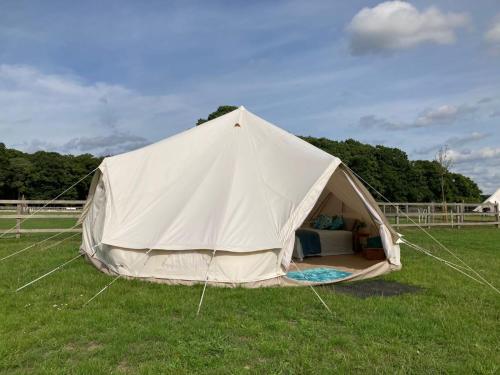 a large white tent in a field of grass at Bell Tent Village Sleeps up to 16! in Bartley