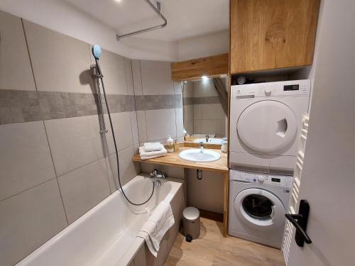 een badkamer met een wasmachine en een wastafel bij Les appartements Place de la Cathédrale in Straatsburg