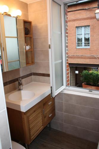 une salle de bain avec un lavabo et une fenêtre dans l'établissement Les Songes d'Héléna, à Honfleur