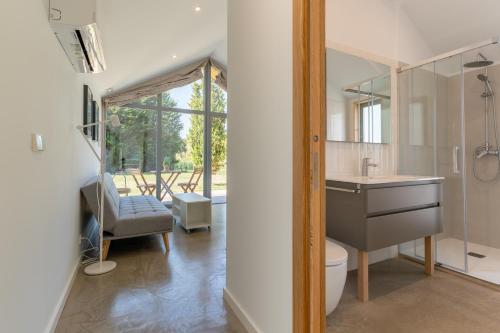 a bathroom with a sink and a toilet and a chair at NaturBatán in Pontevedra