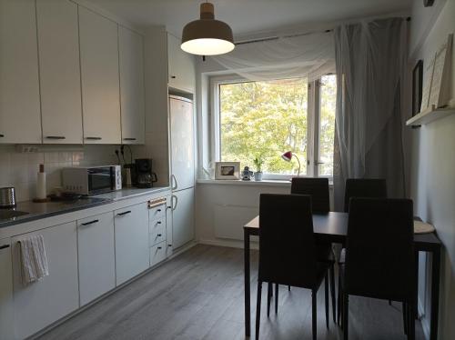 a kitchen with a table and chairs and a window at Ihan Puotilan Metron lähellä in Helsinki