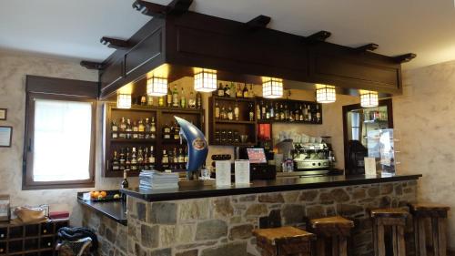 a bar in a restaurant with a stone wall at Hostal Rural La Casa del Peregrino in El Acebo de San Miguel