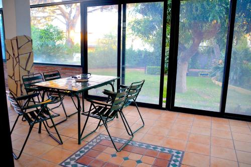 uma sala de jantar com mesa, cadeiras e janelas em Angelo Delle Aci em Acitrezza