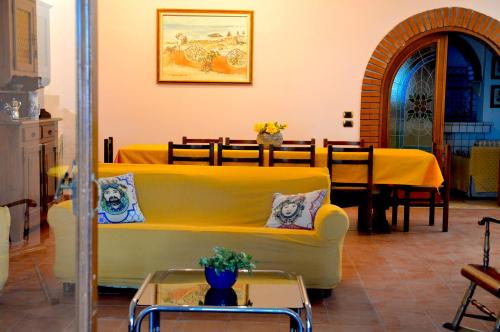 Una sala de estar con un sofá amarillo y una mesa. en Angelo Delle Aci, en Aci Trezza