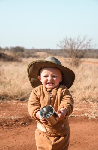 a young boy wearing a cowboy hat holding a object at MILIMA Big 5 Safari Lodge in Hoedspruit