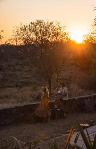 a boy and a girl are standing in front of the sunset at MILIMA Big 5 Safari Lodge in Hoedspruit
