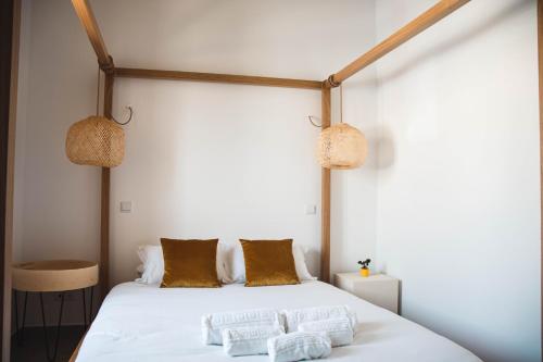a bedroom with a white bed with two pillows on it at Laurus - Charming House in Raposeira