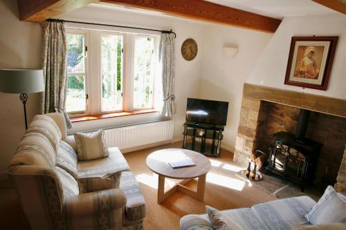 a living room with a couch and a fireplace at Ashfield House in Grassington