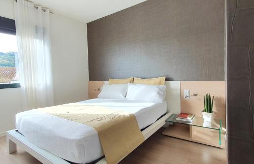 a bedroom with a large white bed and a table at Brisa Marina in A Guarda