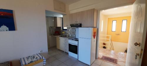 a kitchen with a white refrigerator and a stove at Lakkopetra Beach Apartments in Lakkópetra