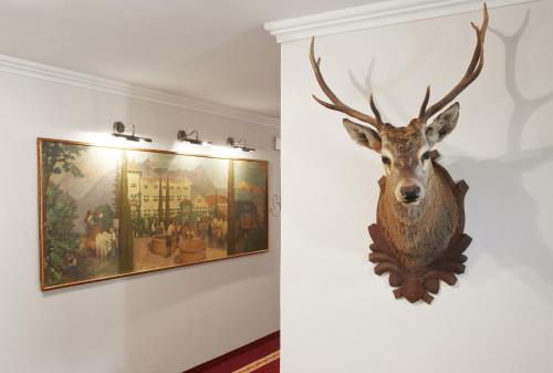 a deer head on a wall next to a painting at Schloss Plars wine & suites in Lagundo