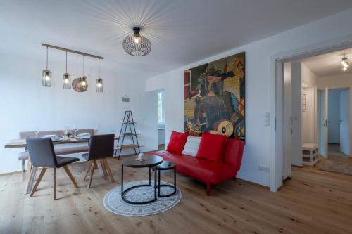 a living room with a red couch and a table at TAMLiving Ljubljana 2BR Center 3 Bridges Great View Kitchen in Ljubljana