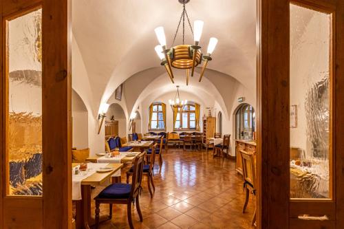 a dining room with tables and chairs and a chandelier at Das Büttner in Schneeberg