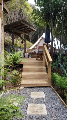 a wooden stairs leading to a yurt with a tent at Tui site in Waihi