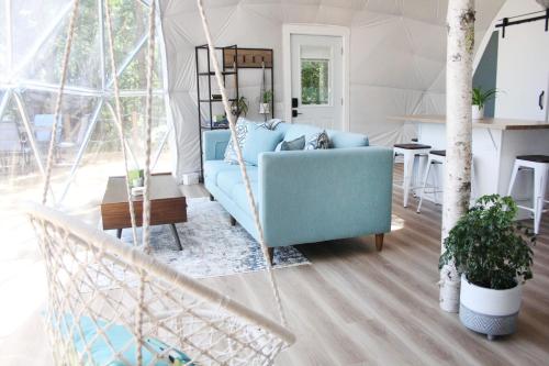 sala de estar con sofá azul y mesa en Geodome water view stay on Grand Manan Island, en Castalia