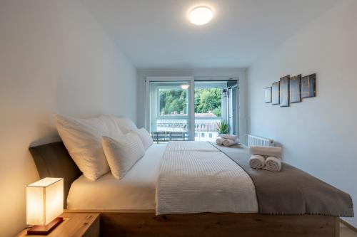a bedroom with a large white bed with a window at TAMLiving Ljubljana 2BR Center 3 Bridges Great View Kitchen in Ljubljana