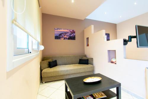 a living room with a couch and a table at Sunset Apartments Free shuttle from Athen's Airport in Spáta