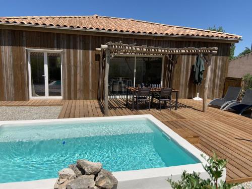 una piscina en una terraza de madera con una mesa en Villa Gebano, en Saussines
