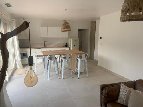 cocina y sala de estar con mesa y sillas en Villa Gebano, en Saussines