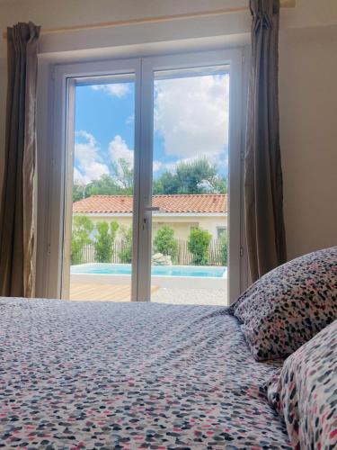 une chambre avec un lit et une grande fenêtre dans l'établissement Villa Gebano, à Saussines