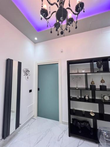 a room with a blue door and a chandelier at RaRoom Supernova H in Torre del Greco