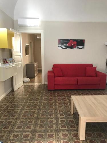 - un salon avec un canapé rouge et une table dans l'établissement Appartamento La Cementina, à Trapani