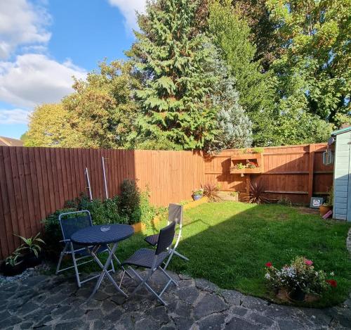 a backyard with a table and chairs and a fence at Private one bedroom apartment with garden and parking in Thame