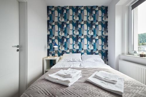 ein Schlafzimmer mit einem Bett mit Handtüchern darauf in der Unterkunft Blue Apartament & Office Kudowa-Zdrój in Kudowa-Zdrój