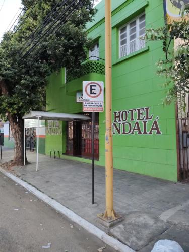 un cartel de hotel India frente a un edificio verde en Hotel Indaiá en Governador Valadares
