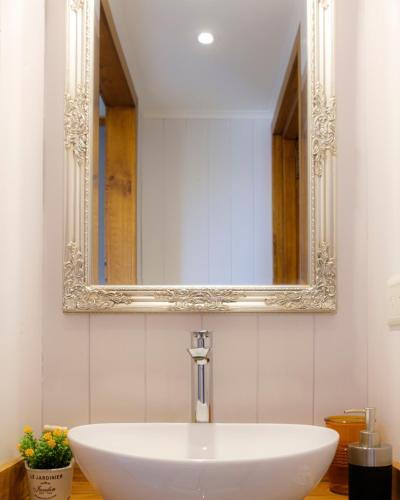 a white sink in a bathroom with a mirror at Oliver Mountain Home Cabin in San Martín de los Andes