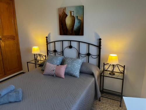 een slaapkamer met een bed met kussens en 2 lampen bij Sarah Kite II Vv, Room 1 in Playa del Burrero