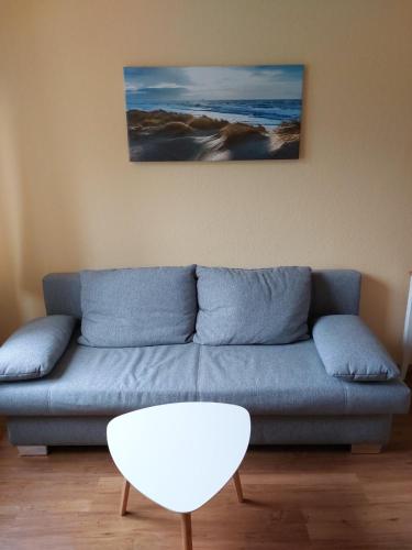 a living room with a blue couch and a table at Ferienwohnung in Kiel in Kiel