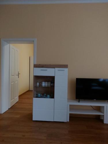 a living room with a white cabinet and a tv at Ferienwohnung in Kiel in Kiel