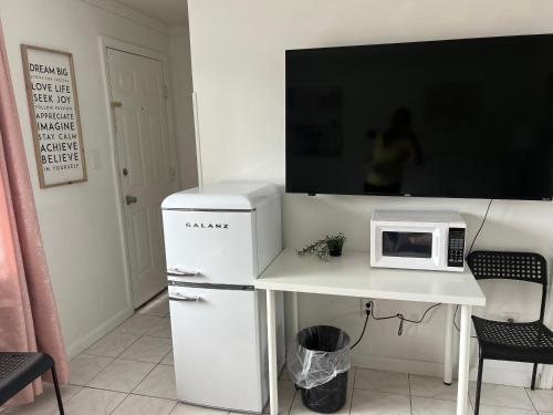 a white refrigerator and a microwave on a white table at Cobmin Ridge Motel in Branchville