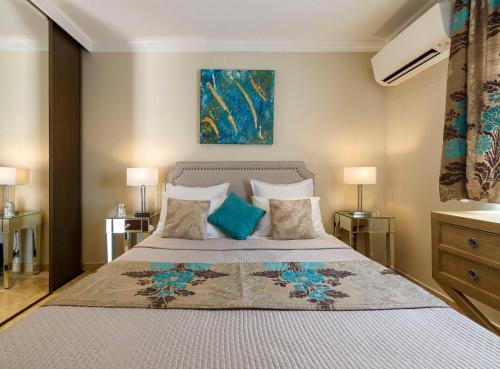 um quarto com uma cama grande e almofadas azuis em La Maisonnette du Clos em La Roquette-sur-Siagne