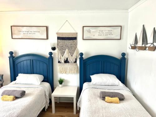 two beds in a room with blue boards at Cobmin Ridge Motel in Branchville