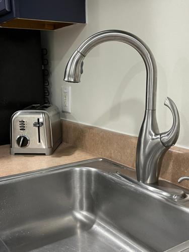 a kitchen sink with a faucet next to a toaster at Cozy Home located in a prime area. in Philadelphia