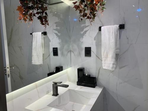 bagno bianco con lavandino e specchio di Pé na areia - Muro Alto - Porto de Galinhas a Porto De Galinhas