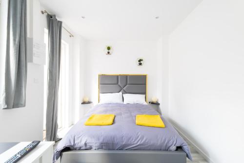 a bedroom with a bed with yellow towels on it at Glm Residences 1 in Saint-Quentin