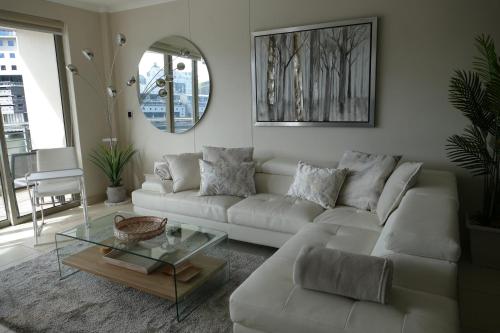 a living room with a white couch and a glass table at Little Venice Self Catering in Bellville