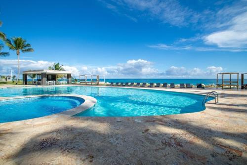 una piscina con el océano en el fondo en Seawinds Penthouse Studio with Rooftop, en Cabarete