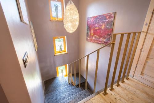 a hallway with a staircase with paintings on the wall at PATEK Premium Apartments - Airport Lawica & MTP & Car races & International trade fairs in Skórzewo