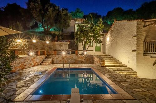 una piscina en medio de un patio por la noche en Olea Skopelos villas with swimming pools & sea view, en Panormos Skopelos