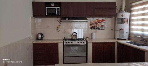 a small kitchen with a stove and a microwave at Departamento El-Shaddai in Tarija