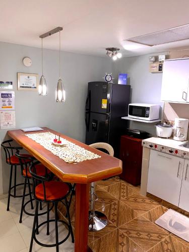uma cozinha com uma mesa de madeira e um frigorífico em Apartment Angeluz em San Andrés