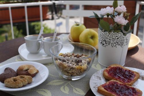 a table with plates of food and cups of coffee at B&B Diana in Marostica