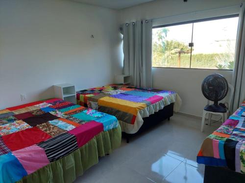 zwei Betten in einem Zimmer mit Fenster in der Unterkunft Casa com 3 quartos em Condomínio de Luxo in Gravatá