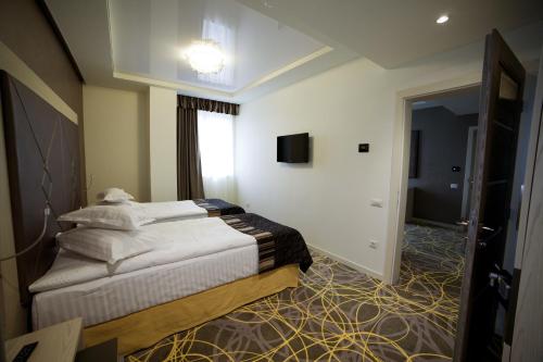 a hotel room with a bed and a television at Exclusive Hotel & More in Sibiu