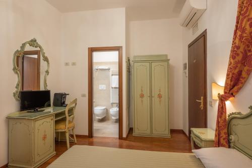 a bedroom with a desk and a bathroom with a toilet at Hotel al Sotoportego in Venice